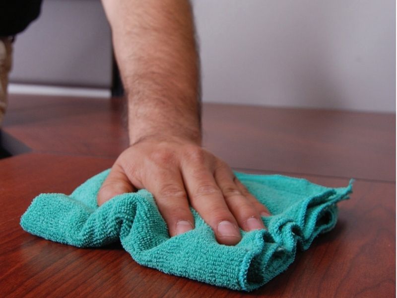 Hand cleaning with green microfiber cleaning towel